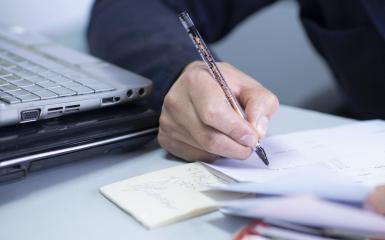 Osoba pisząca na kartce